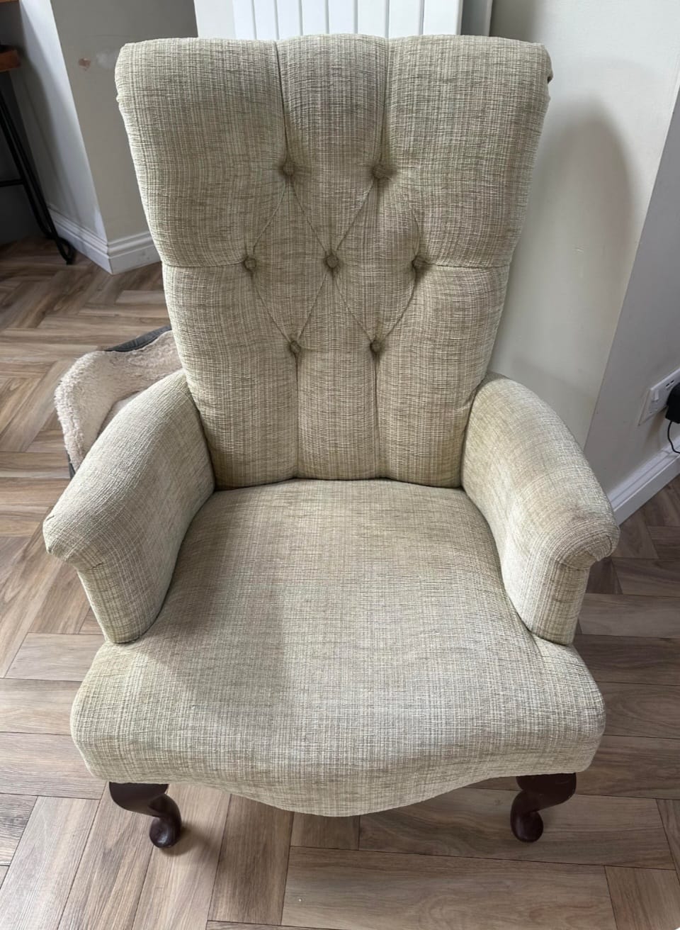 Victorian wingback armchair before restoration, showing worn fabric and visible springs